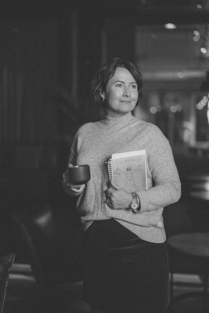 Uusi Puijonsalmen hotellijohtaja Kati Vihma kirja ja kahvikuppi kädessään.